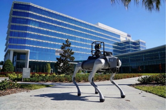 Quadruped security robot with a sensor mast on a corporate campus